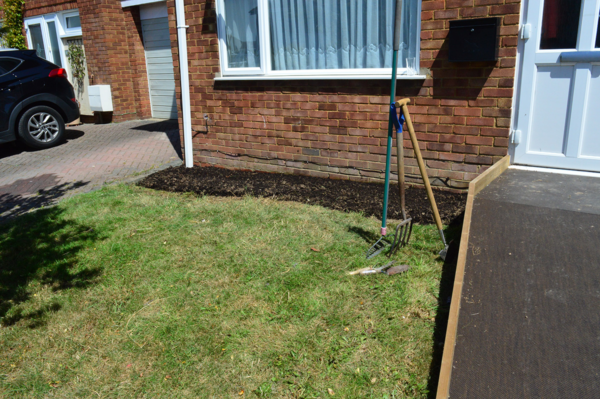 freshly dug over flowerbed, garden fork, edging spade